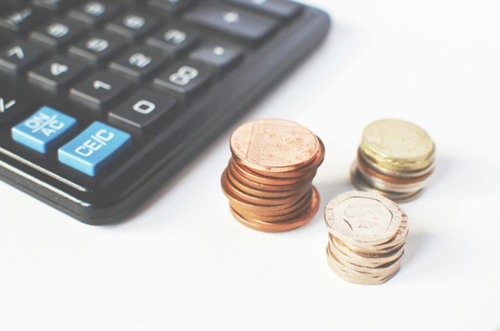 Des pièces sur une table avec une calculette 